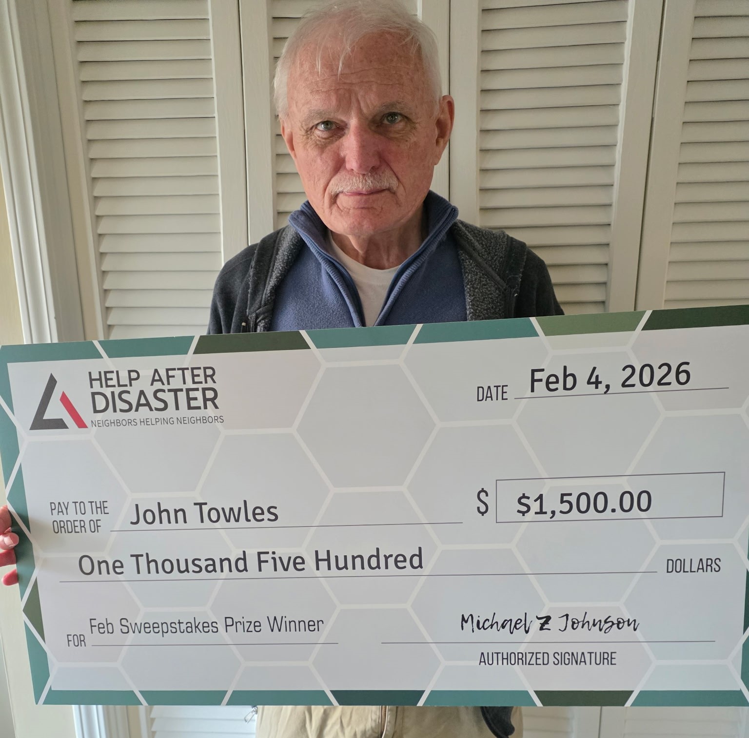 John Towles holding his prize check