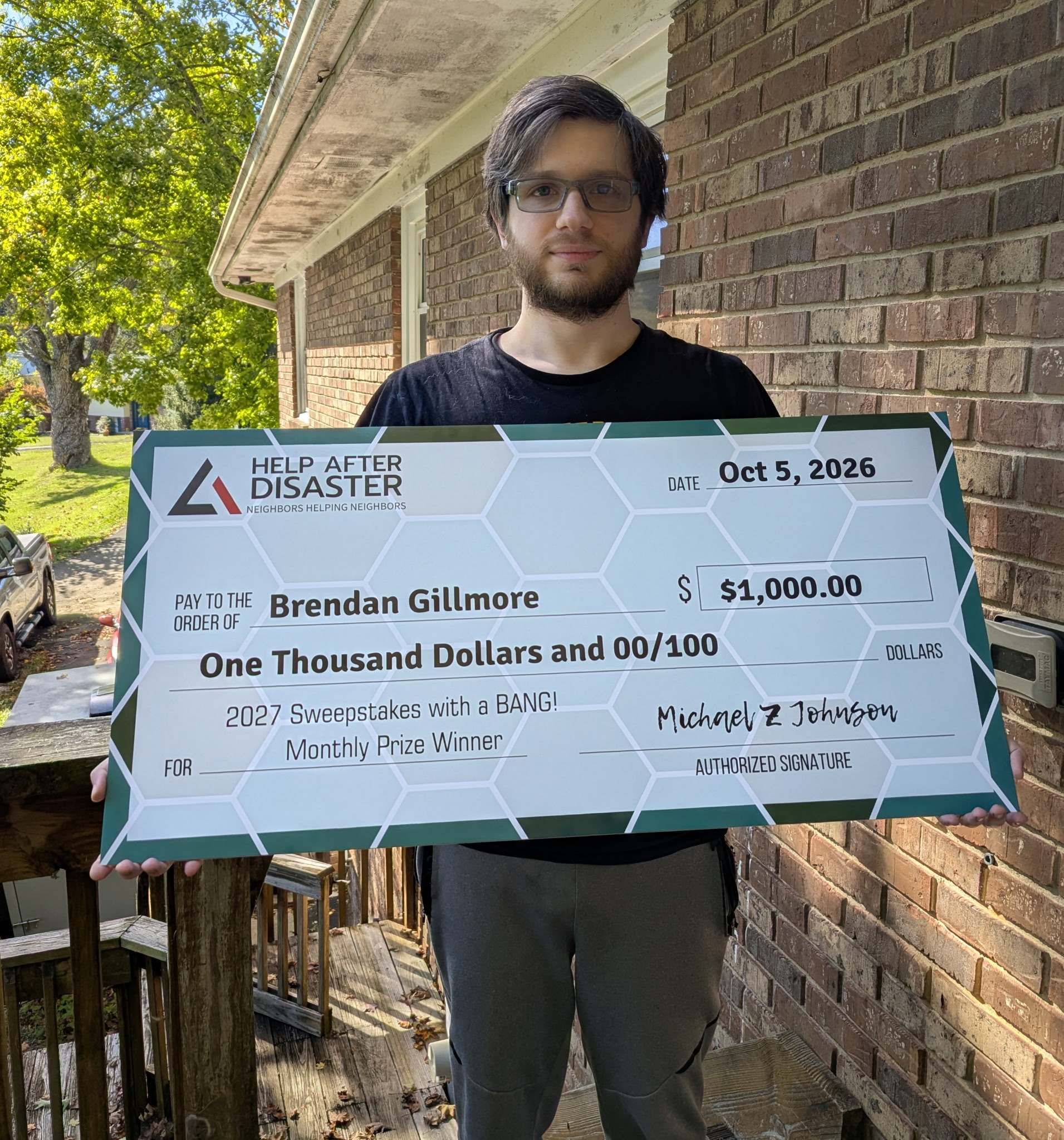 Brendan Gillmore holding his prize check